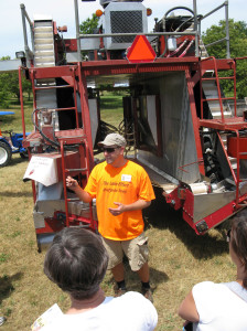 Todd    vineyard manager of Fenn Valley Winey, explains his BEI mechanical grape harvester to guests of the winery's 