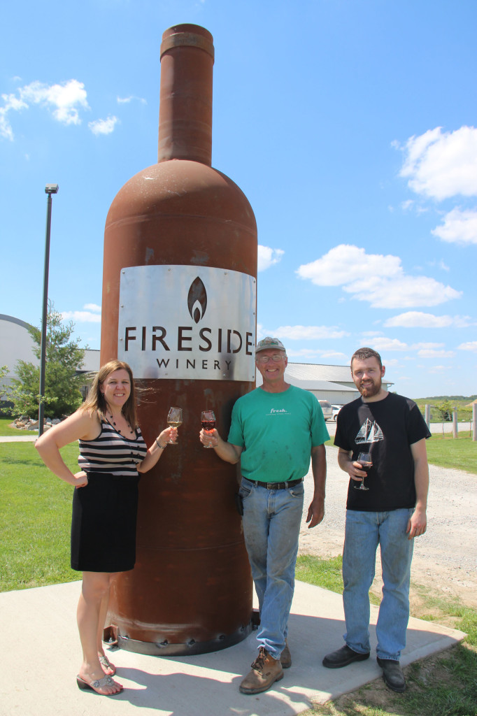 Cassie Bott, Randy Schnebbe and Peter Miller of Fireside Winery next to the Midwest's biggest wine bottle. 