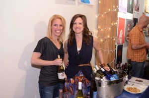 Darcy Morowitz and Kelly Kniewel pouring Michigan wine at an art exhibition.